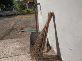 las escobas y los botes de basura están en el borde de la pared foto