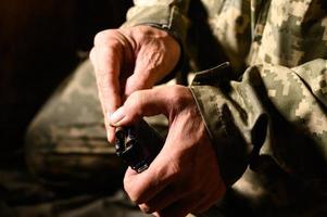 Filling the magazine with combat military assault rifles AK 74, a soldier in a trench holding ammunition for a machine gun. photo