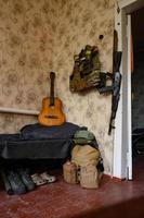 A soldier's combat military assault rifles AK 74 and military ammunition next to a guitar photo