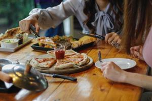 Homemade pizzas are cooked in a charcoal oven and served on wooden trays in the restaurant. Homemade Pizza with Healthy Ingredients and Make Pizza Topping out for customers to choose from. photo