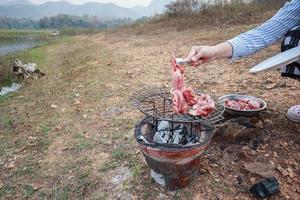 El rosbif a la parrilla es un excelente elemento del menú de la cena durante un viaje de campamento de pesca junto al lago. la carne se sazona en casa y se asa a la parrilla sobre carbón y es una gran adición a cualquier viaje de campamento. foto