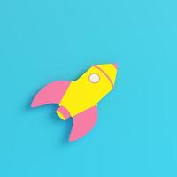 Yellow cartoon styled rocket on bright blue background in pastel colors photo