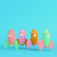 Colorful cartoon styled rocket on bright blue background in pastel colors. Minimalism concept photo