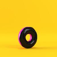 Donut with black glaze on yellow background photo