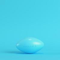 American football ball on bright blue background in pastel colors photo