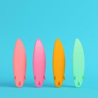 Four colorful surfboards on bright blue background in pastel colors photo