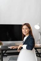 jóvenes empresarias asiáticas trabajan desde casa nuevo proyecto moderno loft, laptop en la oficina, hermosa mujer independiente que trabaja en línea en su oficina. concepto de mujer de negocios asiáticos de belleza. foto