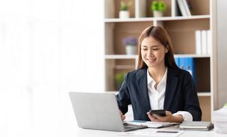 Portrait of confident businesswoman at workplace, smiling woman employee sitting behind laptop. photo