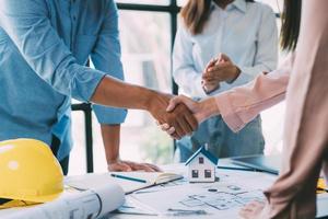 A group of architects are designing a house model, engineers and architects working together to plan a house building project. photo
