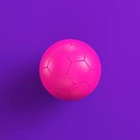 balón de fútbol rosa sobre fondo morado. concepto de minimalismo foto