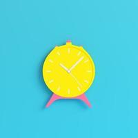 Yellow retro alarm clock on bright blue background in pastel colors. Minimalism concept photo