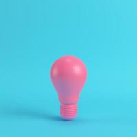 Pink light bulb on bright blue background in pastel colors. Minimalism concept photo