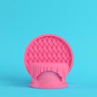 Pink pedestal covered by fabric with round frame on bright blue background in pastel colors photo