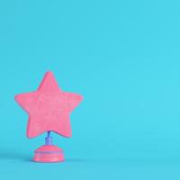 Star with stand on bright blue background in pastel colors. Minimalism concept photo