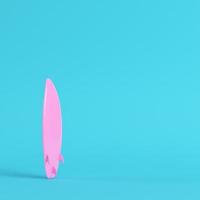 Pink surfboard on bright blue background in pastel colors. Minimalism concept photo