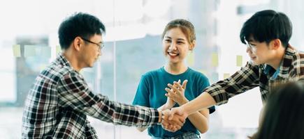 businesspeople are shaking their hands after signing a contract, while standing together in a sunny modern office, close up. Business communication, handshake, and marketing concept photo