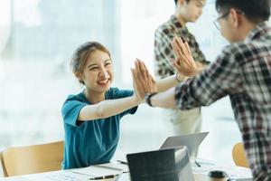 empleados felices chocando los cinco unos a otros. foto