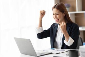 Beautiful Asian girl celebrate with laptop, success happy pose. E-commerce, university education, internet technology, or startup small business concept. photo