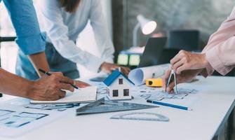 A group of architects are designing a house model, engineers and architects working together to plan a house building project. photo