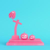 Pink halloween pumpkins with ghost and cross gravestone on bright blue background in pastel colors photo