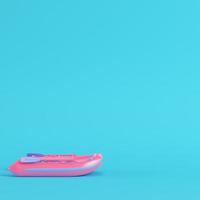bote inflable rosa sobre fondo azul brillante en colores pastel foto