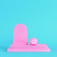 Pink halloween pumpkin with gravestone on bright blue background in pastel colors photo