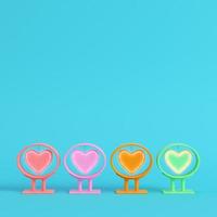 Four colorful neon heart shape in frame on bright blue background in pastel colors photo