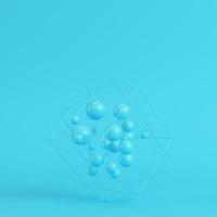 Abstract spheres in wire box on bright blue background in pastel colors. Minimalism concept photo