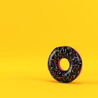 Donut with black glaze on yellow background photo