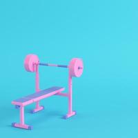 Pink barbell with bench on bright blue background in pastel colors. Minimalism concept photo