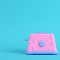 Pink toaster on bright blue background in pastel colors. Minimalism concept photo