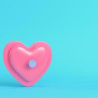 Pink abstract heart shape pinned by nail on bright blue background in pastel colors photo