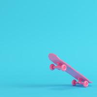 Pink low poly skateboard deck on bright blue background in pastel colors photo