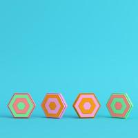 Four colorful abstract hexagons on bright blue background in pastel colors. photo