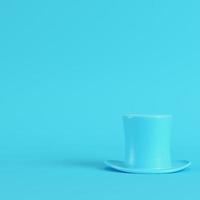 Top hat on bright blue background in pastel colors. Minimalism concept photo