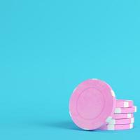 Pink casino chips on bright blue background in pastel colors photo