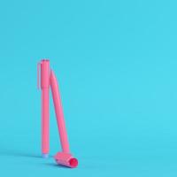 Pink marker pens on bright blue background in pastel colors. Minimalism concept photo