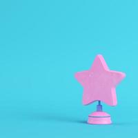 Star with stand on bright blue background in pastel colors. Minimalism concept photo