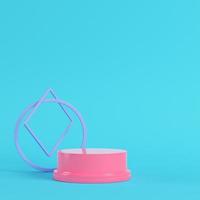 Pink pedestal with geometrical shapes on bright blue background in pastel colors photo