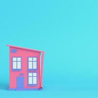 Pink cartoon styled house on bright blue background in pastel colors photo