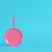 Pink frying pan on bright blue background in pastel colors photo