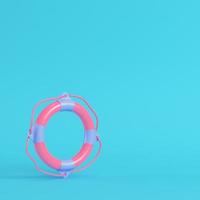 Pink llife buoy on bright blue background in pastel colors photo