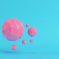 Pink low poly abstract spheres on bright blue background in pastel colors photo