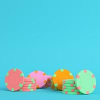 Colorful casino chips on bright blue background in pastel colors