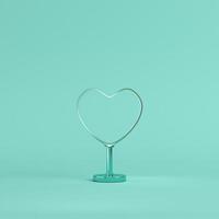 Metal heart shape with stand on bright green background in pastel colors photo