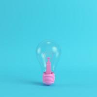 Pink light bulb on bright blue background in pastel colors. Minimalism concept photo