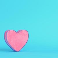 Pink abstract heart shape on bright blue background in pastel colors photo