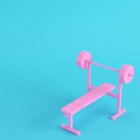 Pink barbell with bench with ball on bright blue background in pastel colors. Minimalism concept photo