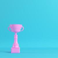 Pink trophy cup on bright blue background in pastel colors photo