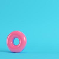 Pink donut on bright blue background in pastel colors photo